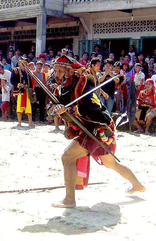 A man holding a Balato (sword) in a Nias war dance.